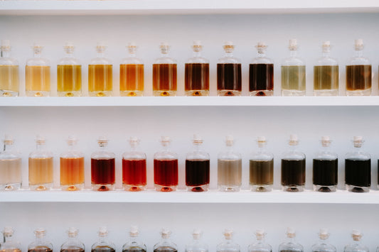 Flacons de parfum et matières premières naturelles illustrant la composition d'une fragrance sans CMR ni phtalates